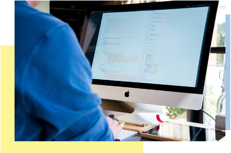 a person looking at code on an Apple monitor